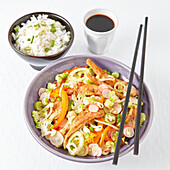 Chicken with crunchy vegetables cooked in a wok and served with rice