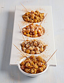 Roasted chickpeas with skewers in small bowls
