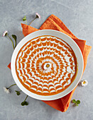 Pumpkin soup decorated with a decorative spider web