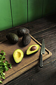 Avocados, ganz und halbiert auf Schneidebrett