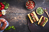 Choripan, Argentinian sandwich on a bun with fresh grilled chorizo on a bed of chimichurri sauce and salsa sauce