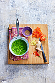 Cook the peas in boiling water. Chop the tomato, ginger and chilli pepper.