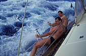 Men in swimming trunks on a sailing boat, Caribbean, America