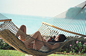 Paar liegt in einer Hängematte, Sandals Halcyon Beach Resort, St. Lucia, Karibik, Amerika