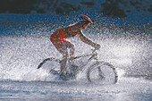 Woman cycling through water