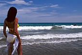 Woman in a bikini watching the surf, Playa del Ingles, Gran Canaria, Canary Islands, Spain