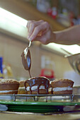 Muffin wird mit Schokolade überzogen