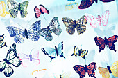 Blick von unten auf mehrere bunte Schmetterlinge aus Papier