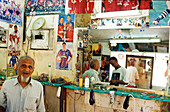 Old man at barber`s, people in shop