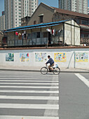 Mann fährt auf einem Fahrrad auf der Strasse, Shanghai, China
