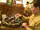 Woman preparing chinese tea at ceremony, Shanghai, China