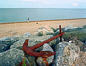 Anchor and angler on beach, Beesands, South England Great Britain