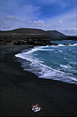 Menschen sonnen sich an einem schwarzen Strand, Ajuy, Fuerteventura, Kanarische Inseln, Spanien Europa, Europa