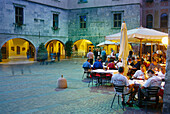 People sitting at tables of a restaurant in the evening, Piazza Tre Novembre, Riva del Garda, Lago di Garda, Trentino, Italy, Europe