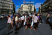 Menschen überqueren eine Strasse an der Puerta del Sol, Madrid, Spanien, Europa