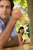 Young girl looking at young man in beer garden, Munich, Bavaria