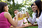 Vier Freunde im Biergarten beim Anstoßen, Starnberger See, Bayern, Deutschland