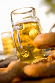 Close-up of pretzel and beer steins in beer garden, Munich, Bavaria