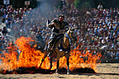Mann reitet auf einem Pferd durch Feuer, Kaltenberger Ritterspiele, Kaltenberg, Bayern, Deutschland, Europa