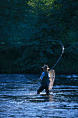 A man with fishing rod standing in the river Moerrumsan Blekinge, Sweden, Europe