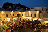 Menschen sitzen am Abend in Restaurants auf der Piazetta Umberto I., Capri, Italien
