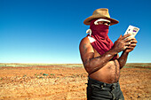 Boxer Lizard with mini gaming console surrounded by flies, breakdown in Simpson Desert, Australia