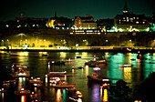 Illuminated boats at night off Soedermalm, Saltsjoen, Stockholm, Sweden