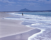 Eine Person kommt aus dem Wasser an den Sandstrand, Praia de Chave, Boavista, Kap Verde, Afrika