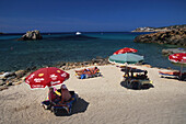 Sonnenbadende mit Sonnenschirmen, Cala Xarraca bei Pontinatx Ibiza, Balearen, Spanien
