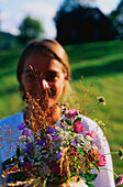 Junge Frau mit Wiesenblumenstrauß