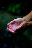 Hand touching waterfall