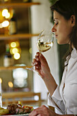 Junge Frau genießt ein Glas Wein beim Abendessen, Steiermark, Österreich