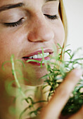 Woman taking a smell at garden herbs