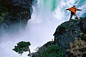 Mann in der Nähe eines Wasserfalls, Naturgewaltl, Paine Nationalpark, Patagonien, Argentinien