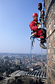 Secured worker climbing up factory chimney, Renovation works on factory , Lower Austria