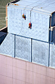 Two workers secured with ropes working on vertical metal surface, renovation works, Duernrohr power plant, Zwentendorf an der Donau, Lower Austria