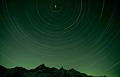 Nocturnal star orbits behind the Weisshorn mountain, Matterhorn 4478m, Zermatt, Switzerland