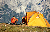 A couple breakfasting in front of a tent, Hutterer Hoess, Kalkalpen, Muehlviertel, Upper Austria