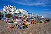 Leute sonnen sich am Strand, Strandleben, Brighton Beach, Brighton, East Sussex, England, Großbritannien