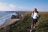 Hiker at the Bedruthan Steps, Coastal walk near Newquay, Cornwall, England, Great Britain