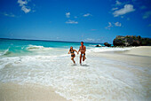 Young couple running along the beach at Sam Lord´s Beach, St.Philip, Barbados, Caribbean