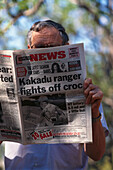 Man reading a Newspaper, Yellow, Water Wetlands, Kakadu NP NT, Australia
