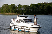 Paar auf Motoorboot, Ellbogensee, Mecklenburgische Seenplatte, Deutschland