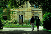 Couple walking in the gardens at Wahnfried Mansion, Bayreuth, Franconia, Bavaria, Germany