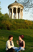 Young couple in front of Monopteros Pavillon in English Garden, Munich, Bavaria, Germany