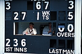 People sitting behind a scoreboard, Village Cricket, Tonbridge, Kent, England Grossbritannien, Europe