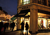 People in front of an illuminated shop in the evening, Regent Street, London, England, Great Britain, Europe