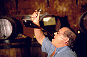 Weinprobe mit einem Porron, ein Glasbehälter mit einer Einfüllöffnung oben und einem trichterförmigen Trinkrohr, Vilafranca del Penedes, Katalonien, Spanien
