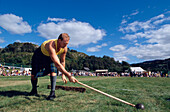 Man with kilt holding a sledge hammer, Glenfinnan Highland Games, Invernesshire, Scotland, Great Britain, Europe