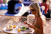 Frau beim Essen, Sa Trincha, Platja de ses Salines, Ibiza Balearen, Spanien